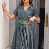 Woman wearing Rustic Elegance blue floral cotton shirt dress with sage belt, short sleeves and full fit-and-flare skirt