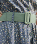 Close-up of Rustic Elegance floral cotton dress showing wide sage green belt, covered buckle, green buttons and gathered waist