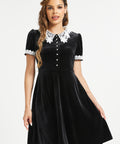 Woman wearing dark academia black velvet dress with white lace Peter Pan collar