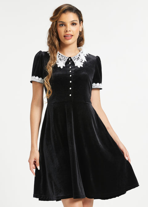 Woman wearing dark academia black velvet dress with white lace Peter Pan collar