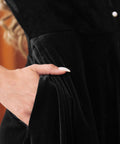 Close-up of a black velvet dress with a side pocket