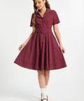 Woman wearing vintage-inspired burgundy corduroy fit and flare midi dress
