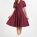 Woman wearing vintage-inspired burgundy corduroy fit and flare midi dress