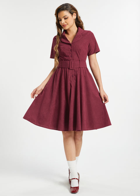 Woman wearing vintage-inspired burgundy corduroy fit and flare midi dress