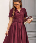 Woman wearing burgundy corduroy fit and flare shirt dress with belt and pockets