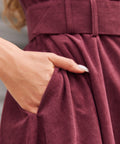 Burgundy corduroy dress side pocket and fabric-covered belt detail