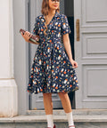 Woman wearing vintage inspired mushroom print dress with notched collar, short sleeves and pleated skirt