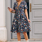 Woman wearing vintage inspired mushroom print dress with notched collar, short sleeves and pleated skirt