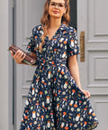 Woman wearing ModCloth navy mushroom print fit and flare dress with button front, belt and pockets