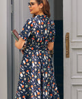 Back view of woman wearing ModCloth navy mushroom print fit and flare dress with belted waist