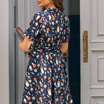 Back view of woman wearing ModCloth navy mushroom print fit and flare dress with belted waist