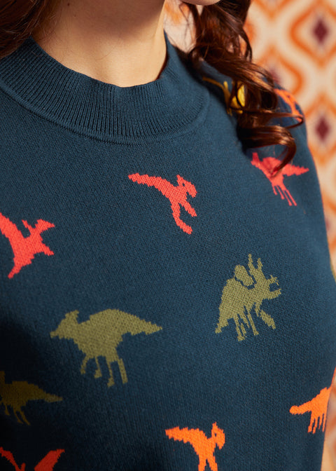 Close-up of navy cotton sweater showing colorful dinosaur pattern, crew neckline, and short puff sleeve