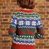 Back view of woman wearing colorful dinosaur Fair Isle sweater with repeating geometric and prehistoric motifs