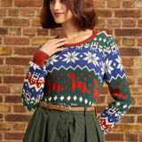 Woman wearing vintage-inspired dinosaur Fair Isle sweater tucked into a high-waisted green skirt