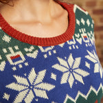 Close-up of 100% cotton dinosaur Fair Isle sweater showing cobalt blue knit, cream motifs, and rust ribbed crew neckline