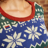 Close-up of 100% cotton dinosaur Fair Isle sweater showing cobalt blue knit, cream motifs, and rust ribbed crew neckline