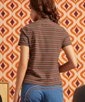 Woman wearing brown striped mock neck short sleeve top with blue jeans, back view showing fitted silhouette and horizontal stripe pattern