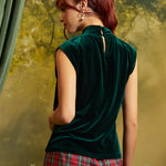 Rear three-quarter view of an emerald green velvet top showing the keyhole back opening with button closure and relaxed silhouette.