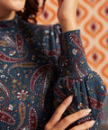 Close-up of blue paisley mock neck top showing gathered bishop sleeve and wide fitted cuff