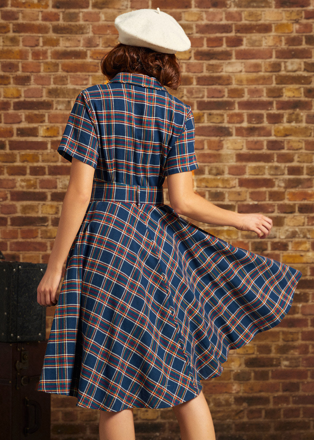 Back view of woman wearing navy plaid belted fit-and-flare dress with short sleeves and full skirt