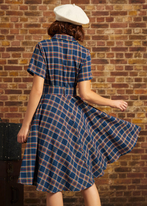Back view of woman wearing navy plaid belted fit-and-flare dress with short sleeves and full skirt