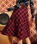 Back view of a woman wearing a red and black buffalo plaid A-line skirt with a zipper