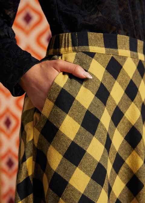 Close-up of mustard and black check cotton skirt showing fitted waistband and side pocket
