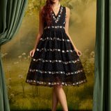 Full-length front view of The Vivienne V-Neck Dress styled with black crisscross-strap heels, highlighting the fitted bodice and flared knee-length skirt.