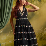 Front view of a black floral embroidered lace dress featuring a deep V-neckline, defined waist, and full fit-and-flare skirt with pink, yellow, and green floral accents.