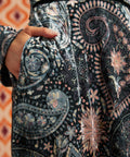 Close-up of Paisley Blooms dress showing intricate floral and paisley print, black waist trim, and side pocket