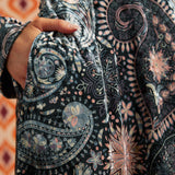 Close-up of Paisley Blooms dress showing intricate floral and paisley print, black waist trim, and side pocket
