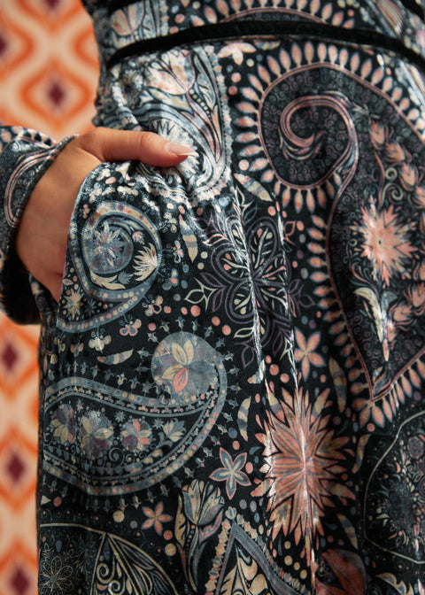 Close-up of Paisley Blooms dress showing intricate floral and paisley print, black waist trim, and side pocket