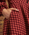 Close-up of side pocket on red, black, and cream plaid dress