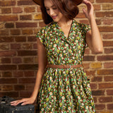 Model in a wide-brim brown hat looking down while wearing the belted floral cotton midi dress, highlighting its retro shirtwaist silhouette and patch pockets.