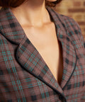Close-up of the notched lapel collar with black piping and brown plaid fabric featuring black checks and fine turquoise stripes.