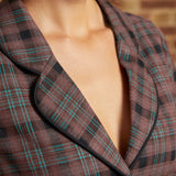 Close-up of the notched lapel collar with black piping and brown plaid fabric featuring black checks and fine turquoise stripes.
