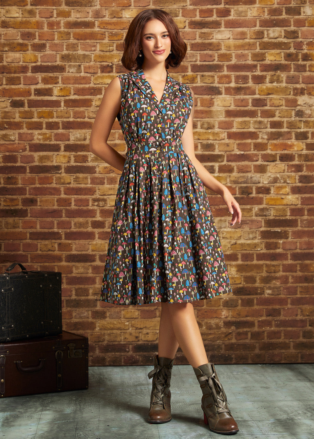 Full-length front view: Model standing in the ModCloth Mushroom Medley Carousel Cutie Dress with a sleeveless collared bodice, button-front closure, gathered flared skirt, and lace-up ankle boots.