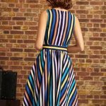 Back view of the striped fit-and-flare dress showing the sleeveless bodice, center back zipper, defined waistband, and flared skirt with vertical stripes.