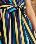Close-up of the removable striped fabric sash tied into a bow at the front waist of the Instant Energy Faux-Wrap Dress.