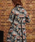 Back view of cat tapestry midi coat showing colorful floral motifs, long sleeves and center back inverted pleat.