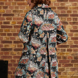 Back view of cat tapestry midi coat showing colorful floral motifs, long sleeves and center back inverted pleat.