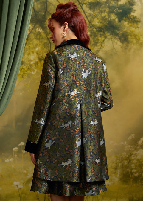 Back view of the Eloise Empire Waist Coat showing the empire waist seam, center back pleat, and whimsical white cat and foliage print.