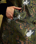 Close-up of the functional side pocket on the Eloise Empire Waist Coat, showing the white cat motif, green foliage, and button-front detailing.