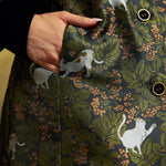 Close-up of the functional side pocket on the Eloise Empire Waist Coat, showing the white cat motif, green foliage, and button-front detailing.