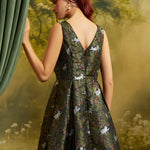 Rear three-quarter view of a ModCloth cat print dress showing the V-back, smocked side panel, fitted waist, and flared skirt.