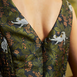 Close-up of a ModCloth party dress's V-shaped back neckline and center back zipper, showing the white cat and botanical print.