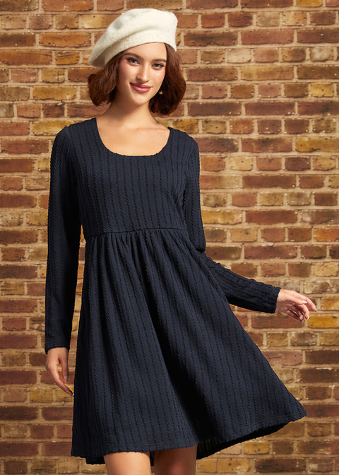 Model wearing a navy cable-textured long sleeve fit-and-flare mini dress with a scoop neckline and empire waist, styled with a white beret.