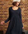 Woman wearing ModCloth's Nostalgic Narrative long sleeve knit dress in navy blue.