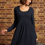 Woman wearing ModCloth's Nostalgic Narrative long sleeve knit dress in navy blue.