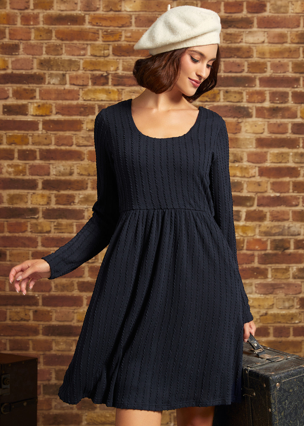 Woman wearing ModCloth's Nostalgic Narrative long sleeve knit dress in navy blue.